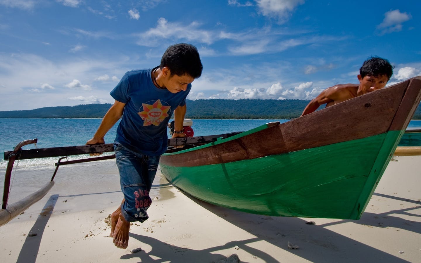 Two men haul a canoe onto the beach on a small island in Central Sulawesi. 