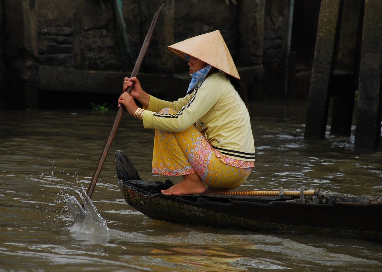 Woman rows to a floating market. 