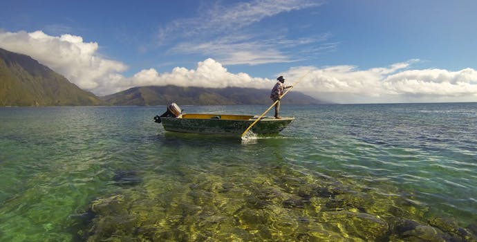 A fisherman paddles his boat.