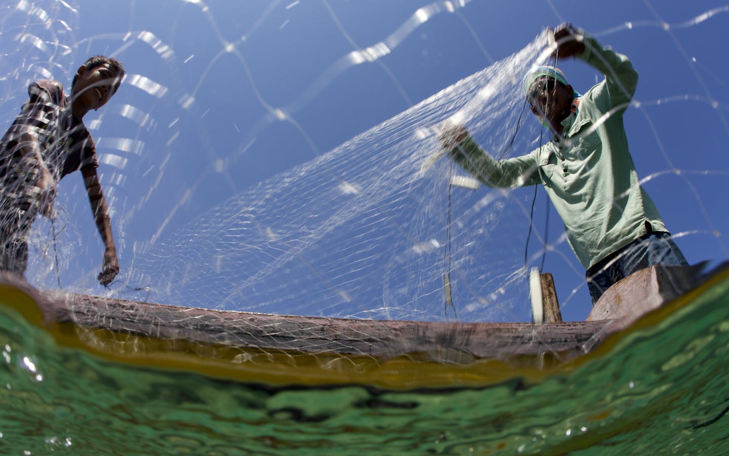 Fisherman cast a net to catch fish 