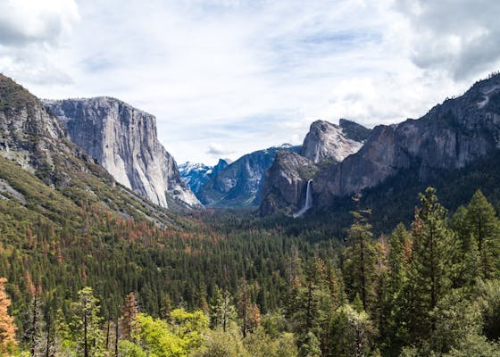 Landscape of a valley in Yosemite National Park, California, with mountains in the distance.