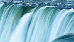 Blue green water racing over the edge of Niagara Falls, Canada